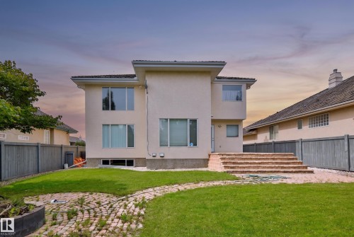 Rear exterior featuring multiple windows, brick steps, and a fenced perimeter - 237 Darlington Crescent Nw, Edmonton, AB - Outdoor