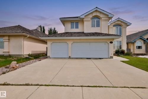 Stucco exterior with arched windows, a two-car garage, concrete driveway, and gabled rooflines - 237 Darlington Crescent Nw, Edmonton, AB - Outdoor With Facade