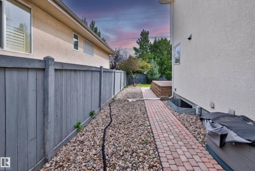 Paver stone pathway bordered by decorative gravel and a privacy fence - 237 Darlington Crescent Nw, Edmonton, AB - Outdoor With Exterior