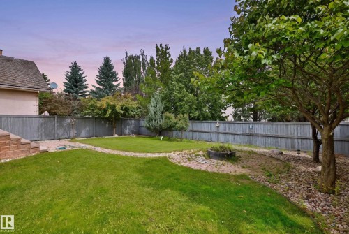 Expansive backyard featuring a manicured lawn, mature trees, and a privacy fence - 237 Darlington Crescent Nw, Edmonton, AB - Outdoor With Backyard