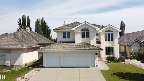 Stucco exterior featuring dual arched windows and a two-car garage - 237 Darlington Crescent Nw, Edmonton, AB - Outdoor With Facade