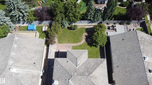 Expansive backyard featuring a manicured lawn, mature trees, and a hardscaped patio area - 237 Darlington Crescent Nw, Edmonton, AB - Outdoor