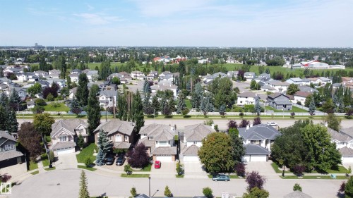 Residential neighborhood featuring detached homes with various architectural styles, mature trees, manicured lawns, and a distant green space - 237 Darlington Crescent Nw, Edmonton, AB - Outdoor With View
