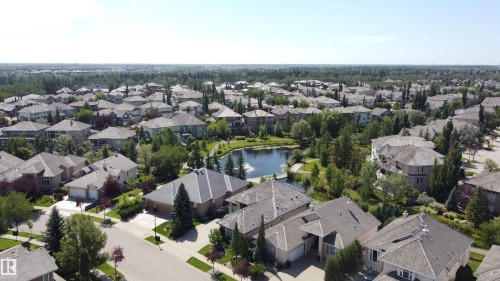 Expansive residential area with a prominent central pond featuring a fountain, surrounded by mature trees and manicured green spaces - 237 Darlington Crescent Nw, Edmonton, AB - Outdoor With View