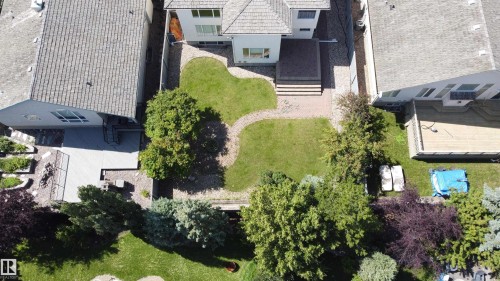 Expansive backyard featuring a large lawn area, mature trees, and a paved patio - 237 Darlington Crescent Nw, Edmonton, AB - Outdoor