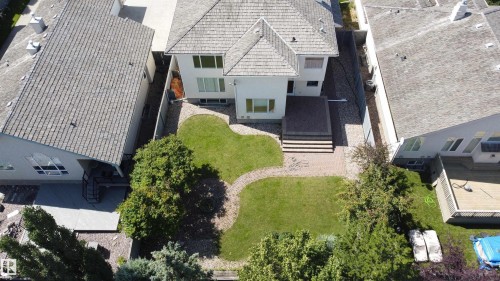 Rear exterior with a multi-level deck, patterned hardscaping, and a landscaped lawn - 237 Darlington Crescent Nw, Edmonton, AB - Outdoor