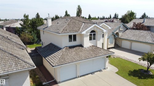 Two-story stucco exterior with wood-shingle roofing, arched window details, and an attached two-car garage - 237 Darlington Crescent Nw, Edmonton, AB - Outdoor