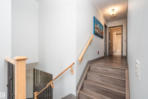 Wood-finish flooring with coordinating stair treads and risers - 16820 57 Street Nw, Edmonton, AB - Indoor Photo Showing Other Room