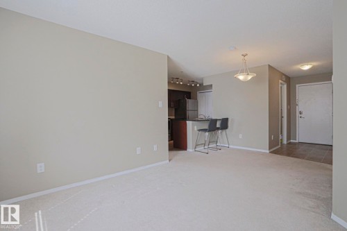 Light-toned carpeting throughout the main living space - #321 270 Mcconachie Dr Nw, Edmonton, AB - Indoor Photo Showing Other Room