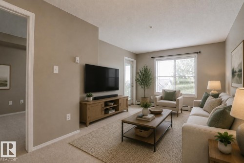 Light-toned wall paint and carpeted flooring - #321 270 Mcconachie Dr Nw, Edmonton, AB - Indoor Photo Showing Living Room