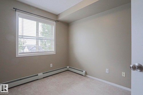 Wall-to-wall carpeting, neutral wall finishes, and a single window with blinds - #321 270 Mcconachie Dr Nw, Edmonton, AB - Indoor Photo Showing Other Room