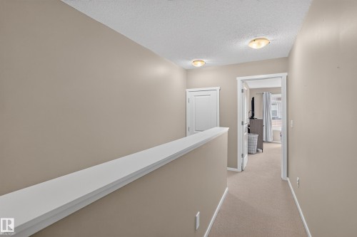 Carpeted hallway with neutral wall tones and white trim - #53 603 Watt Bv Sw, Edmonton, AB - Indoor Photo Showing Other Room