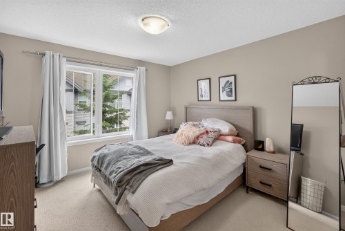 Bedroom featuring a double window with white trim, neutral carpet flooring, and a flush mount ceiling light fixture - #53 603 Watt Bv Sw, Edmonton, AB - Indoor Photo Showing Bedroom