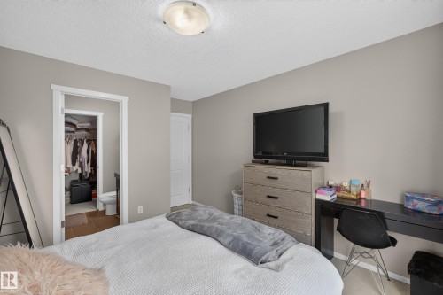 Neutral-toned bedroom featuring a textured ceiling, a flush-mount ceiling light, and light-colored walls - #53 603 Watt Bv Sw, Edmonton, AB - Indoor Photo Showing Bedroom