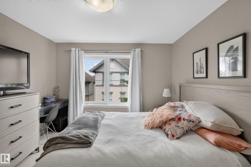 Bedroom featuring a double window, light gray wall paint, and a textured ceiling - #53 603 Watt Bv Sw, Edmonton, AB - Indoor Photo Showing Bedroom