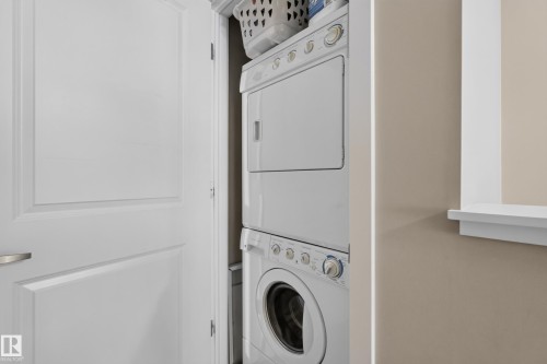 Stackable laundry appliances integrated within a dedicated alcove - #53 603 Watt Bv Sw, Edmonton, AB - Indoor Photo Showing Laundry Room
