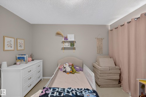 Neutral-toned walls complement the textured ceiling - #53 603 Watt Bv Sw, Edmonton, AB - Indoor Photo Showing Bedroom