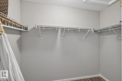 Walk-in closet featuring wire shelving, white wall paint, wood-finish flooring, and white trim - 