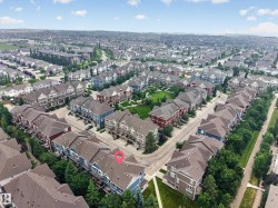 Expansive aerial overview of a residential development featuring numerous townhome-style properties - 