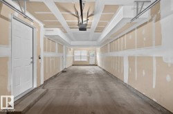 Spacious garage featuring a concrete floor, overhead door track system, and two white panel doors - 