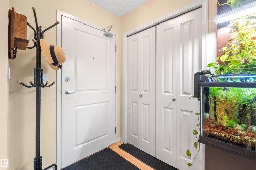 Entry area with a paneled door, bi-fold closet doors, and wood-finish flooring - #209 103 Ambleside Drive Sw, Edmonton, AB - Indoor Photo Showing Other Room