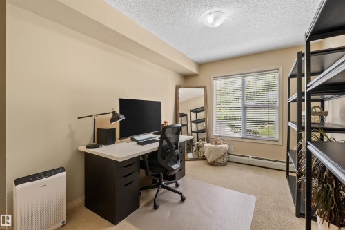 Carpeted flooring, window with blinds, overhead lighting, neutral wall color, built-in shelving - #209 103 Ambleside Drive Sw, Edmonton, AB - Indoor Photo Showing Office