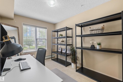 Neutral-toned walls complement the window with horizontal blinds, providing natural light - #209 103 Ambleside Drive Sw, Edmonton, AB - Indoor Photo Showing Office