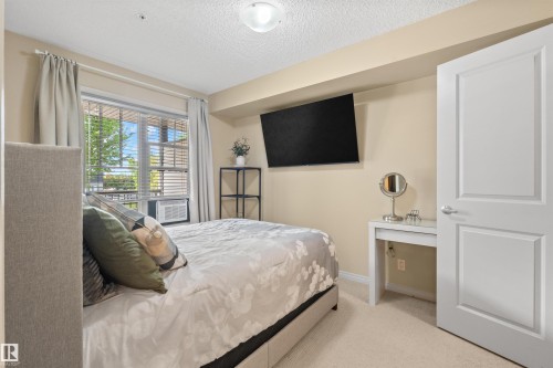 Window with horizontal blinds and drapery rods - #209 103 Ambleside Drive Sw, Edmonton, AB - Indoor Photo Showing Bedroom