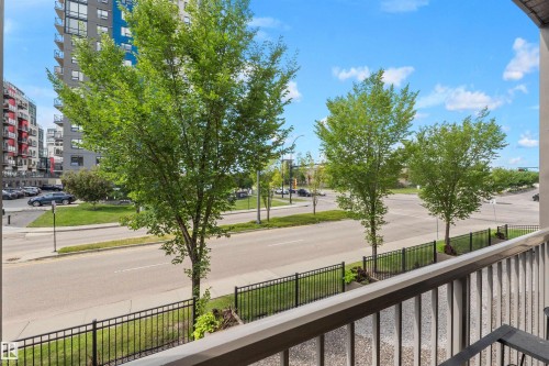 Balcony with metal railing overlooking street with mature trees and adjacent buildings - #209 103 Ambleside Drive Sw, Edmonton, AB - Outdoor
