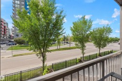Balcony with metal railing overlooking street with mature trees and adjacent buildings - 