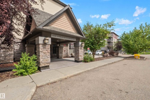 Covered entrance with stone-clad columns and overhead lighting - #209 103 Ambleside Drive Sw, Edmonton, AB - Outdoor