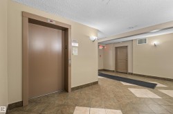 Elevator access with call buttons, wall-mounted sconces, and neutral-toned wall paint - 