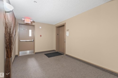 Hallway with carpet flooring and neutral painted walls - #209 103 Ambleside Drive Sw, Edmonton, AB - Indoor Photo Showing Other Room