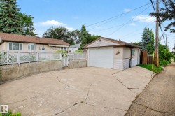 Detached single-car garage with overhead door, concrete driveway, and side access - 