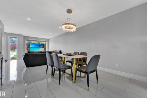 Dining area featuring a contemporary chandelier, light-toned tile flooring, and recessed ceiling lighting - 9329 Connors Road Nw, Edmonton, AB - Indoor Photo Showing Dining Room