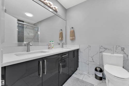 Dual vanity with integrated sinks and brushed nickel faucets, set against a light grey wall - 9329 Connors Road Nw, Edmonton, AB - Indoor Photo Showing Bathroom