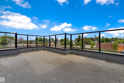 Expansive outdoor patio featuring a concrete surface, contemporary glass railings, and a low-profile perimeter wall - 9329 Connors Road Nw, Edmonton, AB - Outdoor With View