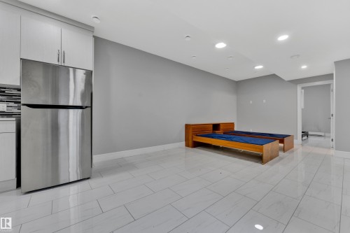 Spacious room featuring light gray walls, recessed lighting, and tile flooring - 9329 Connors Road Nw, Edmonton, AB - Indoor