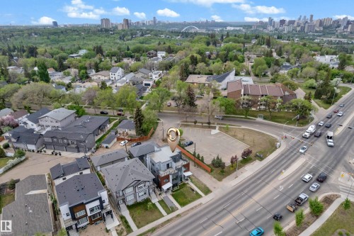 Aerial perspective showcasing the property's location within a developed neighborhood, featuring residential buildings, mature trees, and a visible roadway - 9329 Connors Road Nw, Edmonton, AB - Outdoor With View