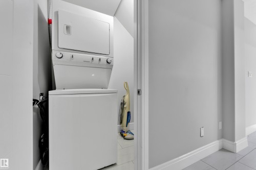 Dedicated laundry area featuring a stacked washer and dryer unit - 9329 Connors Road Nw, Edmonton, AB - Indoor Photo Showing Laundry Room