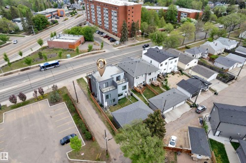 Modern multi-story dwelling featuring a flat roofline, integrated balconies, and a grey and white exterior facade - 9329 Connors Road Nw, Edmonton, AB - Outdoor With View