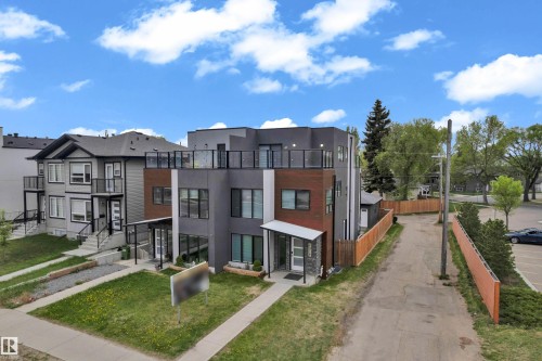 Modern multi-story dwelling featuring a flat roofline and a balcony with glass railings - 9329 Connors Road Nw, Edmonton, AB - Outdoor