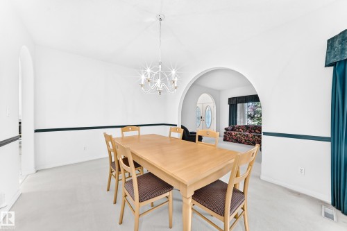 Arched doorways, overhead chandelier, and light-colored carpeting - 209 Carmichael Close Nw, Edmonton, AB - Indoor Photo Showing Dining Room
