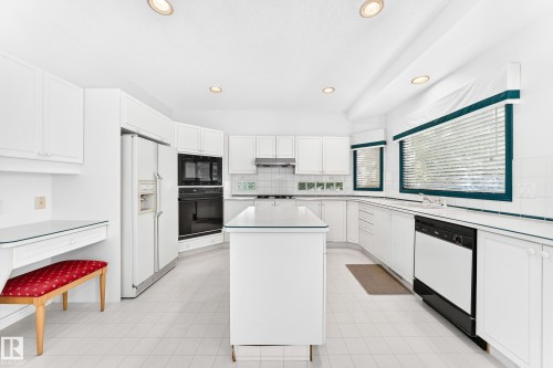 White cabinetry, recessed lighting, central island, integrated desk area, and durable tile flooring - 209 Carmichael Close Nw, Edmonton, AB - Indoor Photo Showing Kitchen