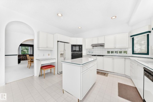 White shaker cabinetry, recessed lighting, tile flooring, kitchen island with glass top, and a built-in desk area - 209 Carmichael Close Nw, Edmonton, AB - Indoor Photo Showing Kitchen