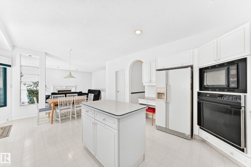 Kitchen featuring a central island, white cabinetry, integrated wall oven, and built-in microwave - 209 Carmichael Close Nw, Edmonton, AB - Indoor Photo Showing Kitchen