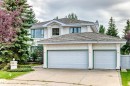 Stucco exterior with a multi-level roofline, prominent two-car garage with overhead doors, and a concrete driveway - 209 Carmichael Close Nw, Edmonton, AB  - Outdoor 