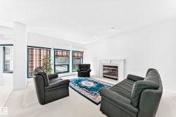 Living area featuring a fireplace with a white mantel, multiple large windows, and recessed lighting - 