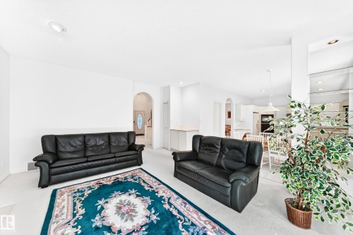 Recessed lighting, arched doorways, white walls, and light-colored carpeting throughout - 209 Carmichael Close Nw, Edmonton, AB - Indoor Photo Showing Living Room