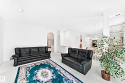Recessed lighting, arched doorways, white walls, and light-colored carpeting throughout - 